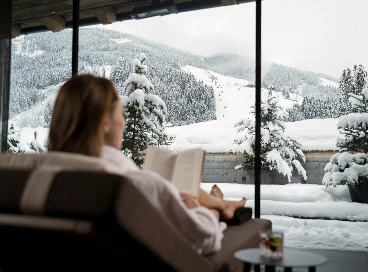 ausblick-header Frau genießt Ausblick auf die Piste vom Zwölferhaus Ruheraum aus