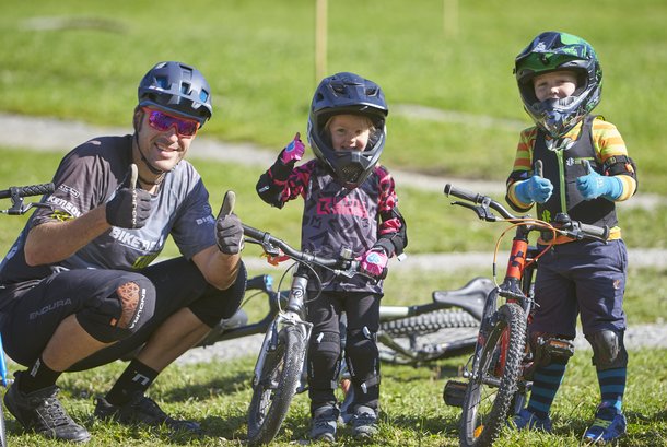 Mann mit zwei kleinen Kindern beim Mountainbiken