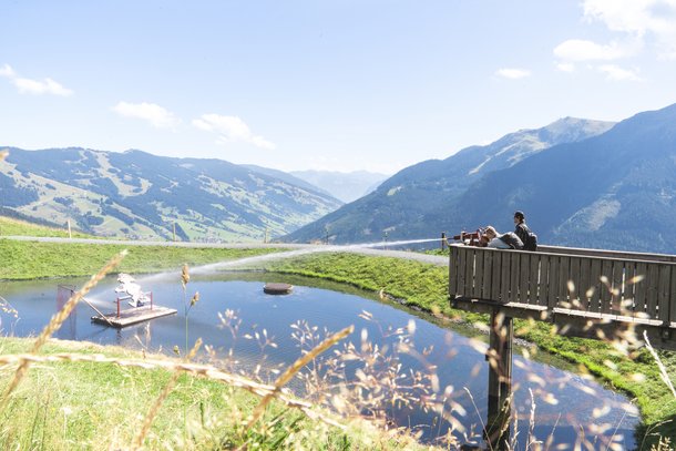 Zwei Personen schießen mit einer Wasserkanone auf ein Ziel im See