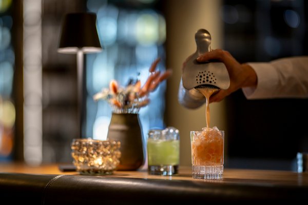 Bar Mitarbeiter schenkt Cocktail einen von zwei Cocktails ein