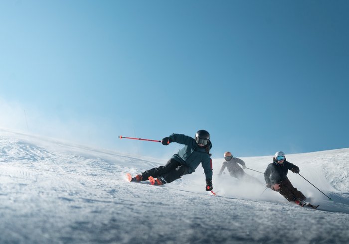 Drei Skifahrer bei schönem Wetter in Saalbach Hinterglemm